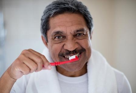 Older man brushing teeth