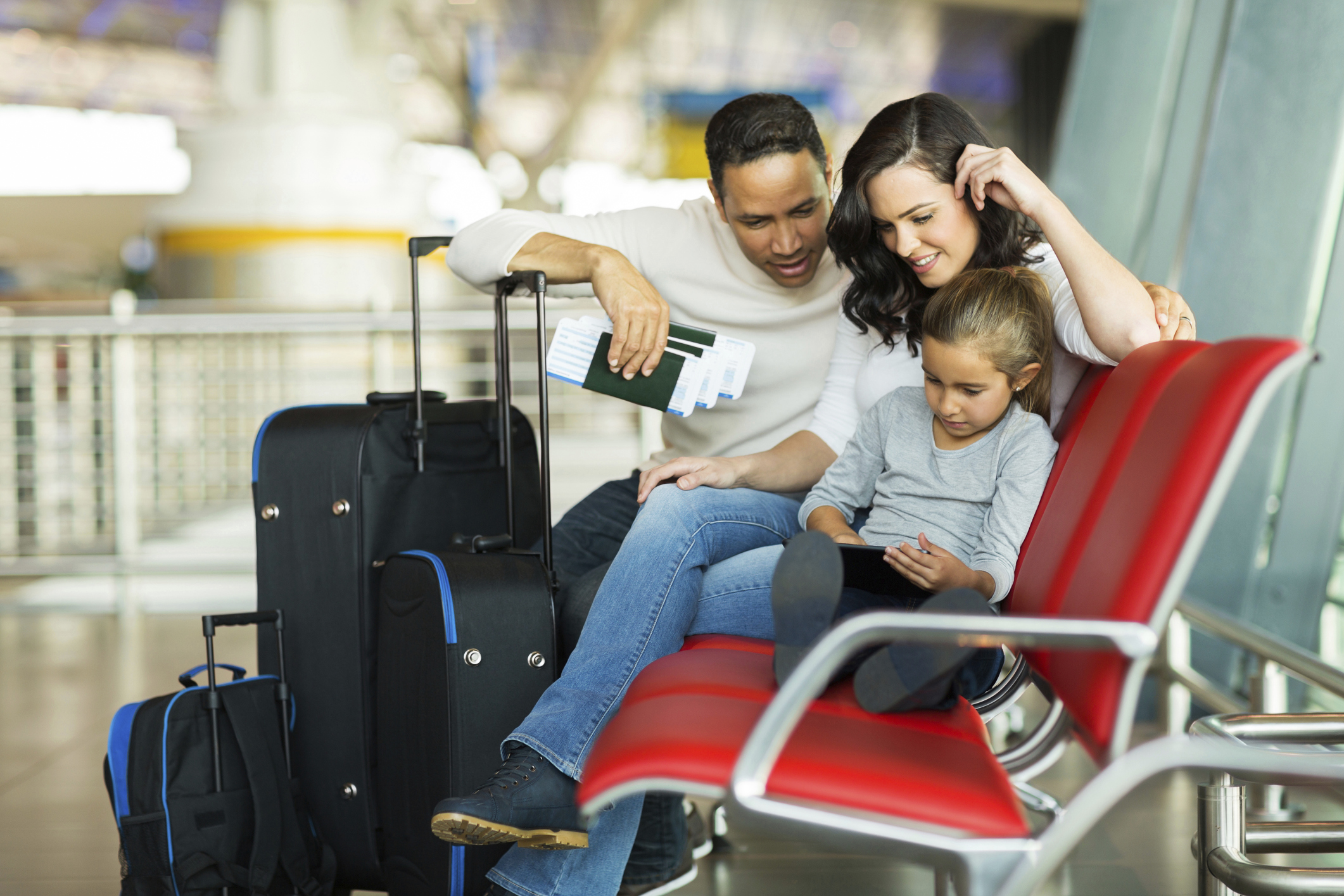 Picture of a racially diverse family sitting in an airport
